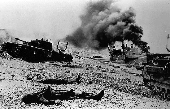 Canadenses e tanques Churchill jazem na praia.